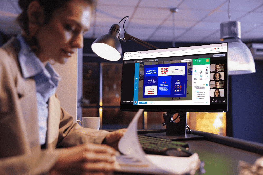 Mulher trabalhando em um escritório à noite, revisando documentos enquanto participa de uma videoconferência online exibida no monitor do computador. A tela mostra uma apresentação corporativa com informações sobre a empresa PepsiCo no Brasil, com participantes visíveis em miniaturas de vídeo à direita.